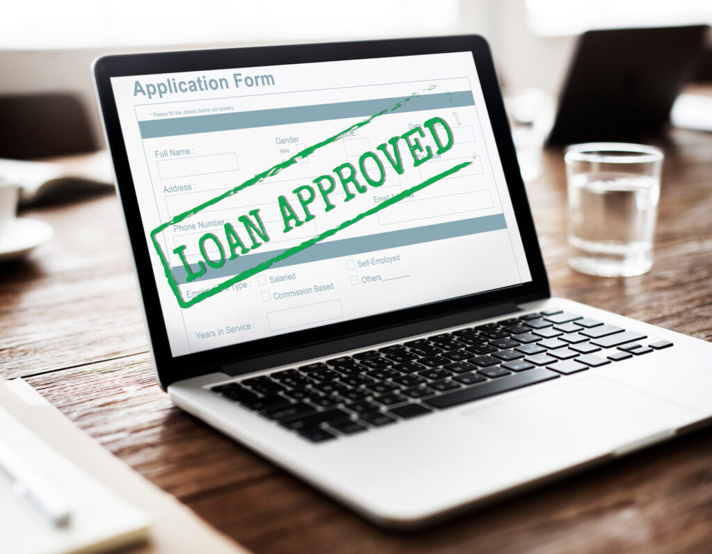 Image of a loan being approved on a laptop.