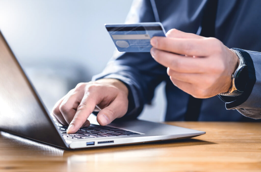 Image showing a man using credit card and laptop.