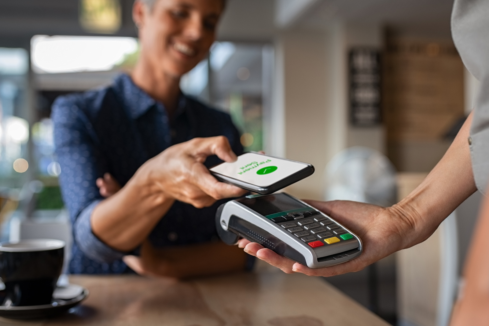 Image of a women using a phone app to pay at a store.