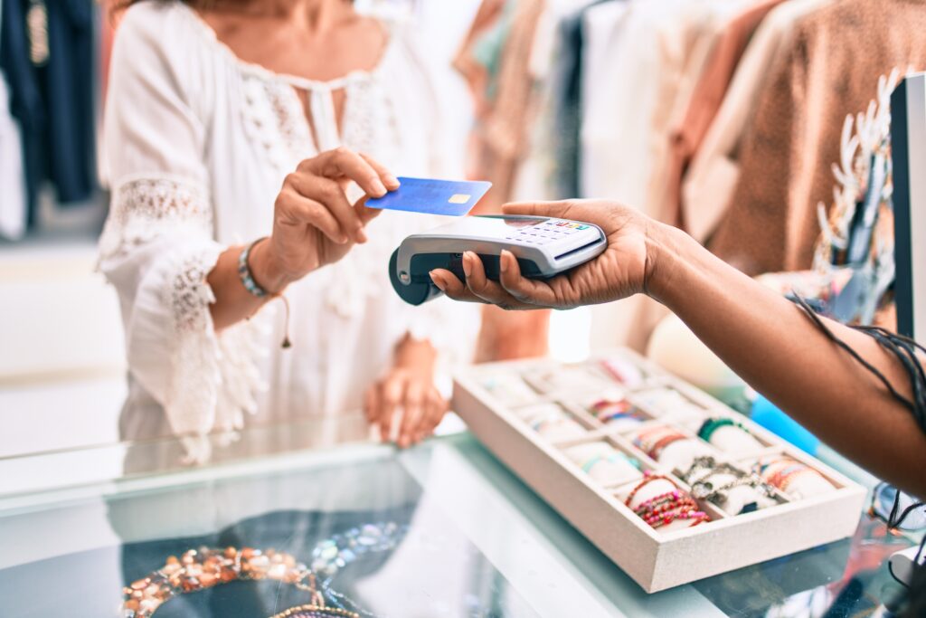 Image of a Woman paying using a credit card at a store.