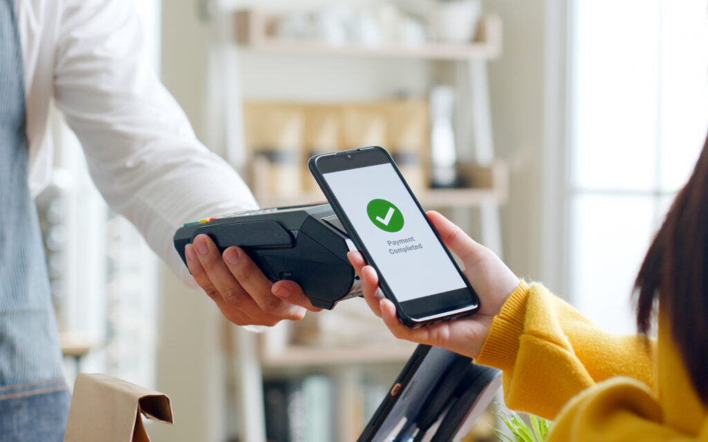 Image of a women paying at a store with her phone.