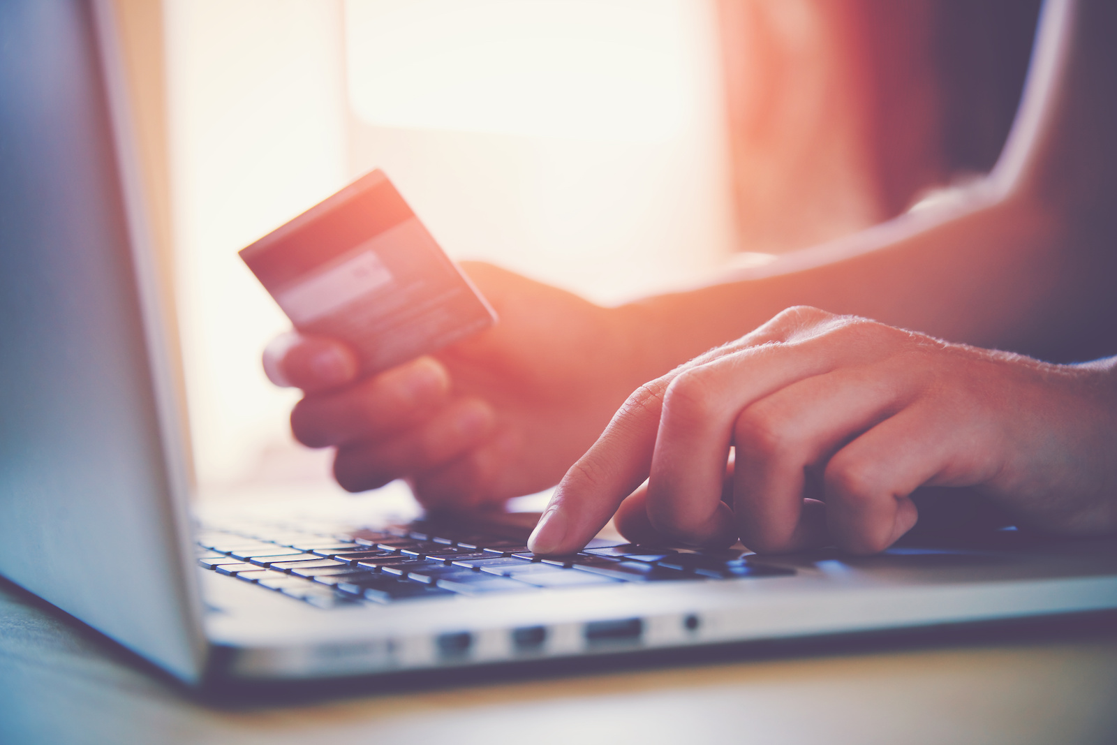 Image of a customer using a credit card to make an online purchase.